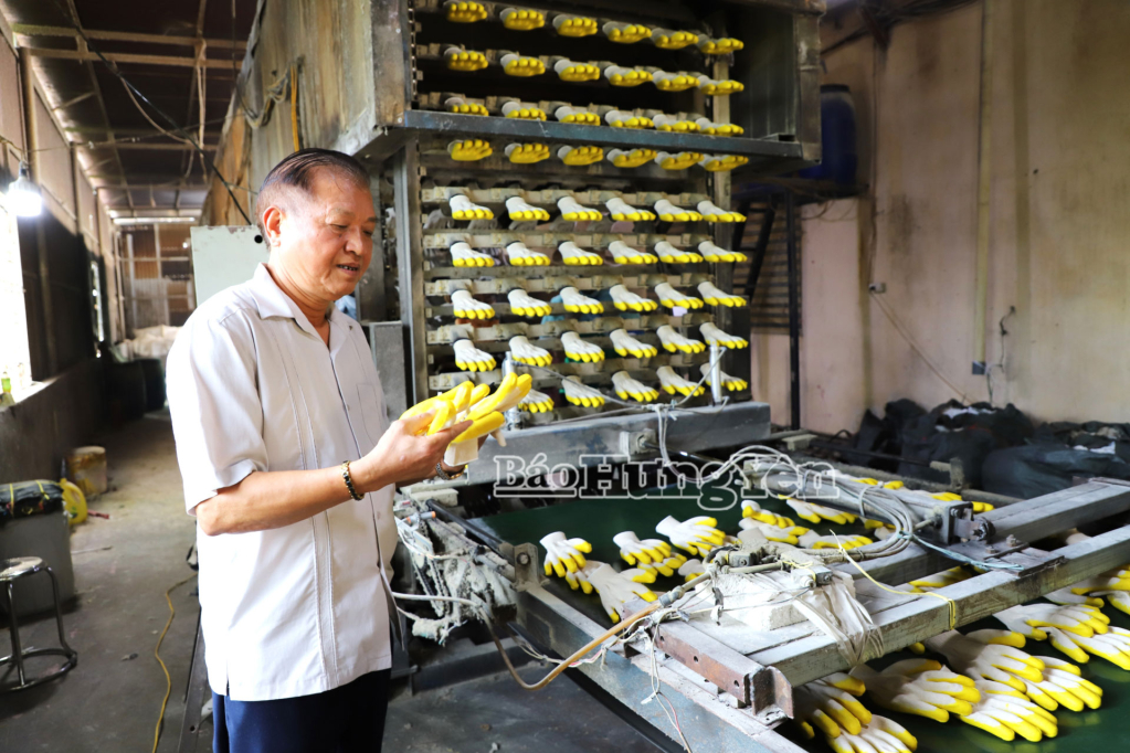Ông Trần Văn Vực kiểm tra chất lượng sản phẩm găng tay trước khi xuất khẩu.