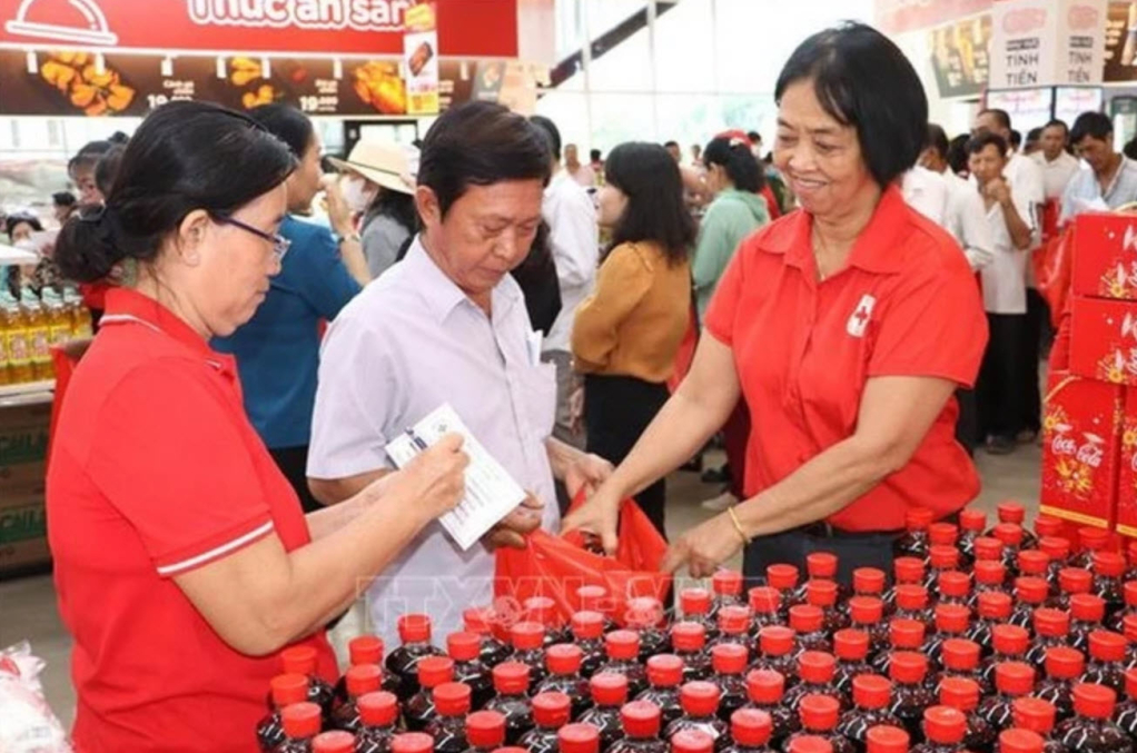 Người dân nhận hàng thiết yếu tại Phiên chợ Phiên chợ Nhân đạo 2025 hướng về người nghèo tỉnh Tiền Giang. (Ảnh: Minh Trí/TTXVN)