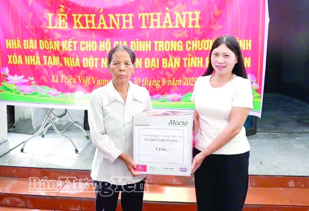 Bà Phạm Thị Hiền, thôn Đức Nhuận, xã Triệu Việt Vương được nhận quà của địa phương trong ngày nhận bàn giao nhà đại đoàn kết. 