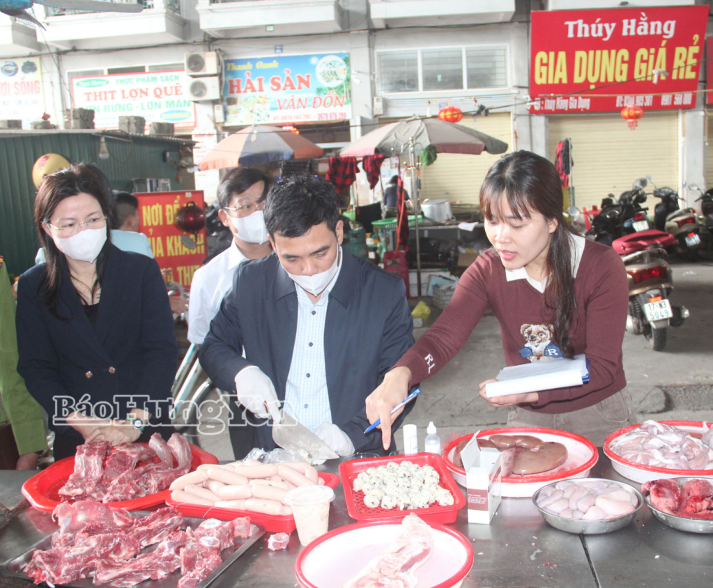 Thành viên đoàn kiểm tra nhanh hàn the trong sản phẩm chế biến từ thịt lợn được bày bán tại chợ Vĩnh Trà (phường Trần Lãm).