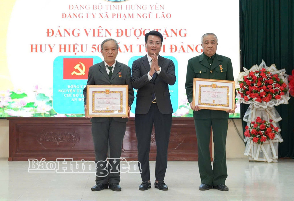 Bí thư Đảng ủy xã Phạm Ngũ Lão trao Huy hiệu Đảng tặng các đảng viên. Ảnh: Đào Doan