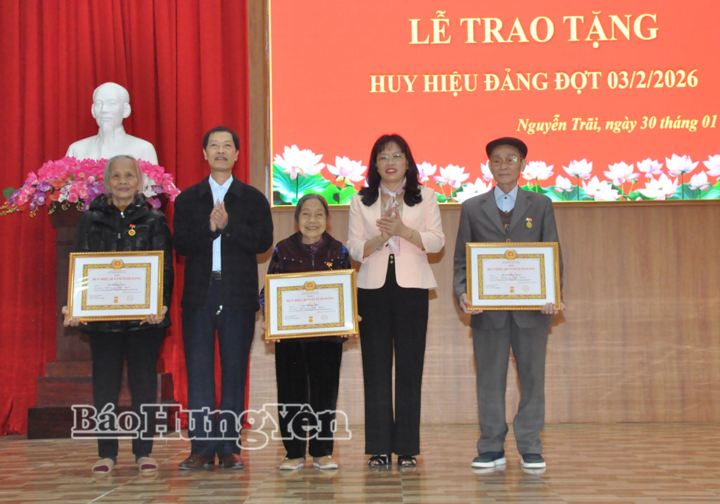 Lãnh đạo Đảng ủy xã trao Huy hiệu Đảng tặng các đảng viên. Ảnh: Đào Doan