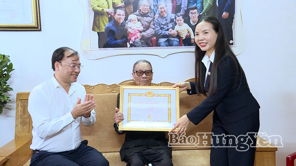 Đồng chí Ngô Thị Kim Hoàn, Ủy viên Ban Thường vụ Tỉnh ủy, Phó Chủ tịch Thường trực Ủy ban MTTQ Việt Nam tỉnh trao Huy hiệu 70 năm tuổi Đảng tặng đảng viên Phan Văn Bút. Ảnh: Minh Nguyệt