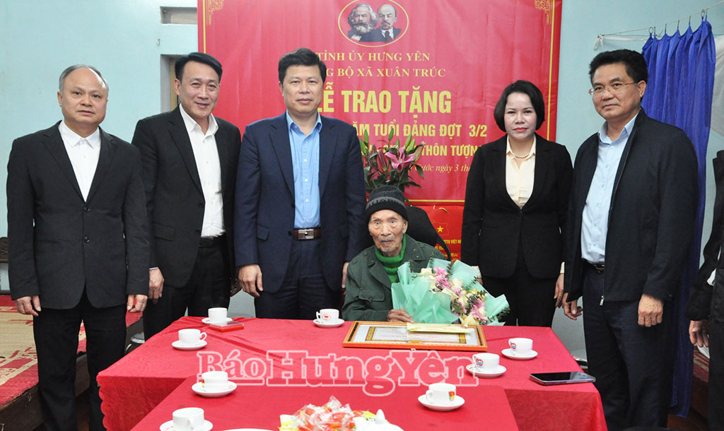 Đồng chí Phó Bí thư Thường trực Tỉnh ủy, Chủ tịch Ủy ban MTTQ Việt Nam tỉnh Trần Quốc Toản cùng các đại biểu trao Huy hiệu 75 năm tuổi Đảng tặng đảng viên Đào Văn Nhân. 