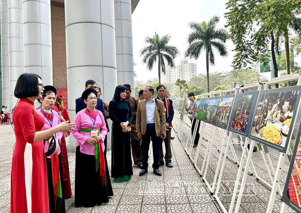 Hướng dẫn viên giới thiệu tới du khách không gian triển lãm ảnh “Hưng Yên: Qua miền di sản”.