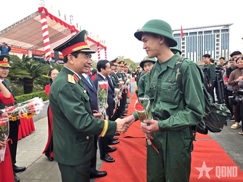 Đại tướng Phan Văn Giang, Ủy viên Bộ Chính trị, Phó bí thư Quân ủy Trung ương, Bộ trưởng Bộ Quốc phòng tặng hoa, động viên thanh niên lên đường nhập ngũ. Ảnh: QĐND