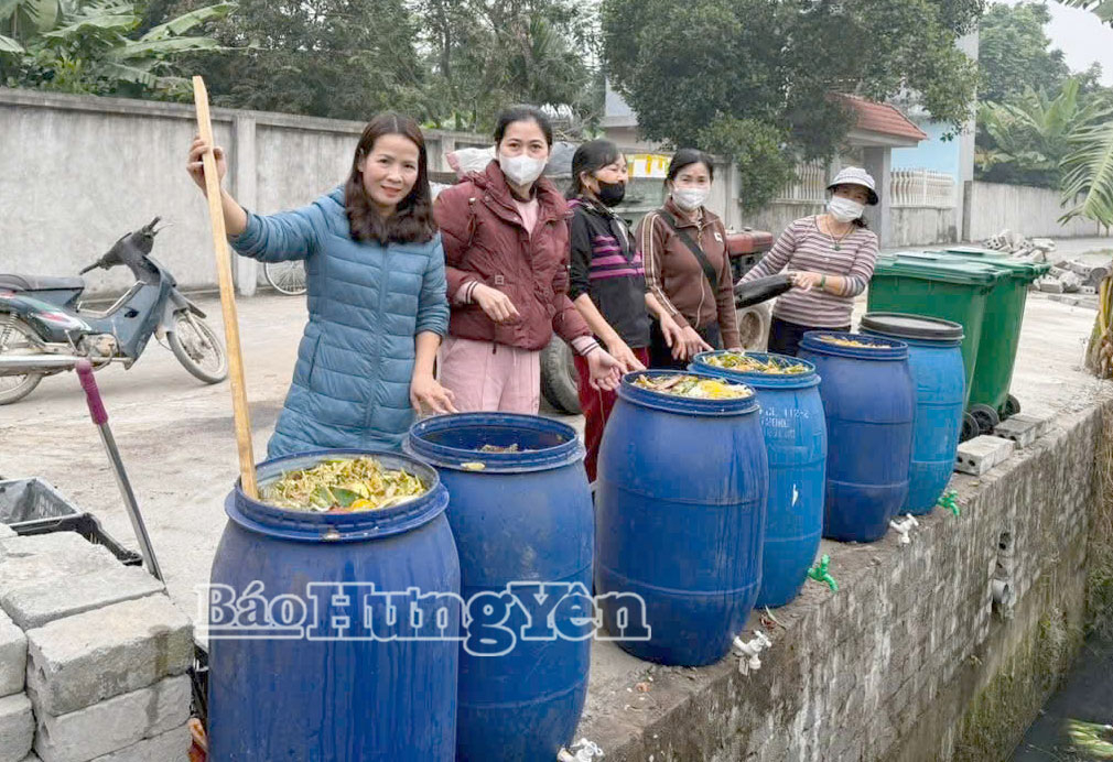 Chị Tôn Thị Tần (người đứng đầu tiên) hướng dẫn chị em phụ nữ xã Lạc Đạo xử lý rác thải hữu cơ.