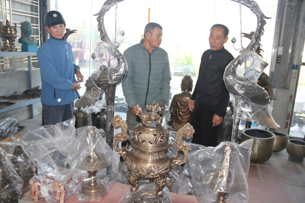 Khách hàng đến tìm hiểu, mua các sản phẩm tại làng nghề đúc đồng An Lộng (xã Ngọc Lâm).
