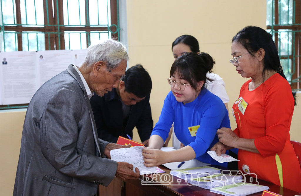 Thành viên tổ bầu cử hỗ trợ cử tri cao tuổi tham gia bỏ phiếu.