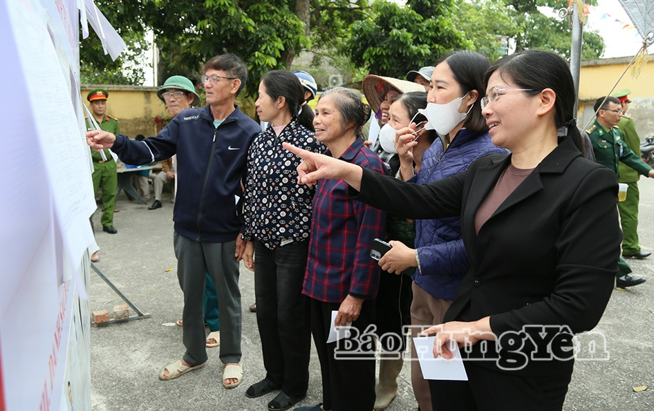 Cử tri theo dõi danh sách người ứng cử niêm yết tại Khu vực bỏ phiếu số 2 (thôn Vạn Xuân Nam), xã Đông Thụy Anh.