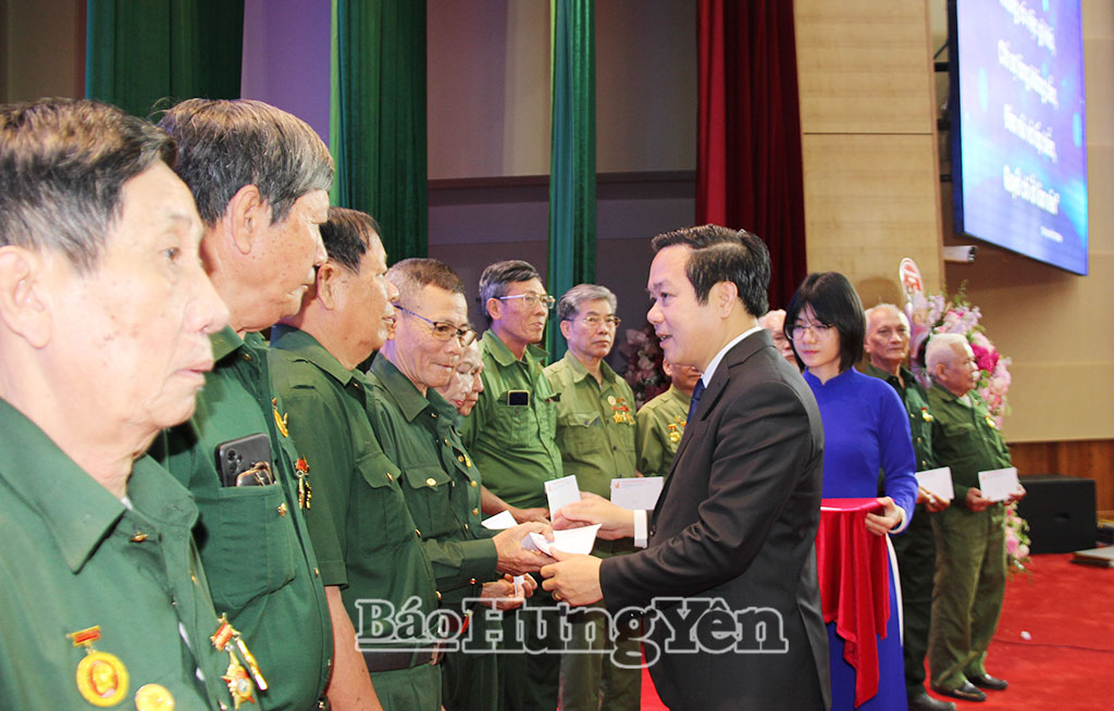 Đồng chí Chủ tịch UBND tỉnh Phạm Quang Ngọc trao quà tặng các cựu thanh niên xung phong.