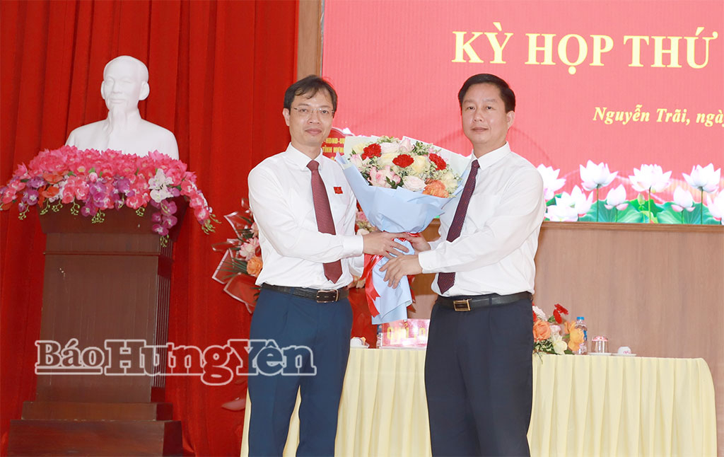 Đồng chí Vũ Thanh Vân, Ủy viên Ban Thường vụ Tỉnh ủy, Giám đốc Sở Công Thương tặng hoa chúc mừng đồng chí Chủ tịch HĐND xã Nguyễn Trãi khóa XXI.