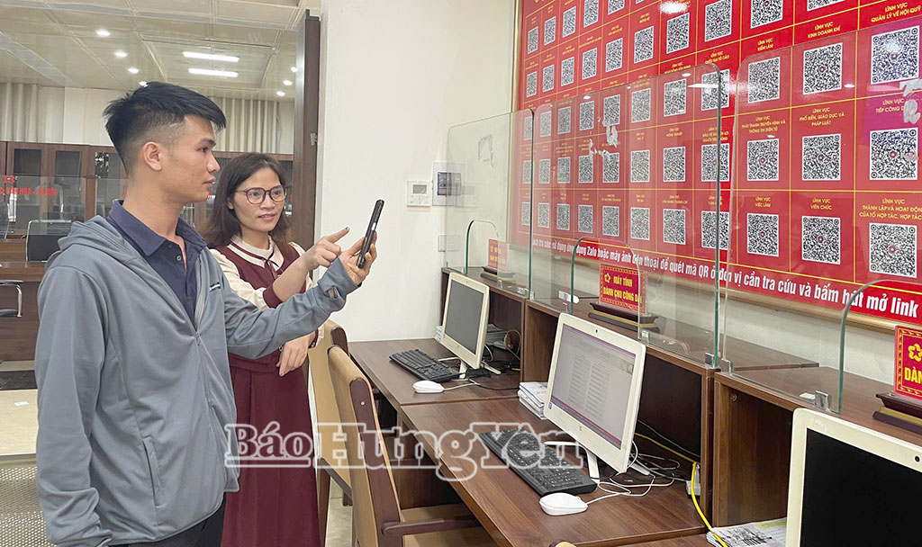 Nhân viên Trung tâm Phục vụ hành chính công xã Như Quỳnh hướng dẫn người dân tra cứu thủ tục hành chính qua mã QR.