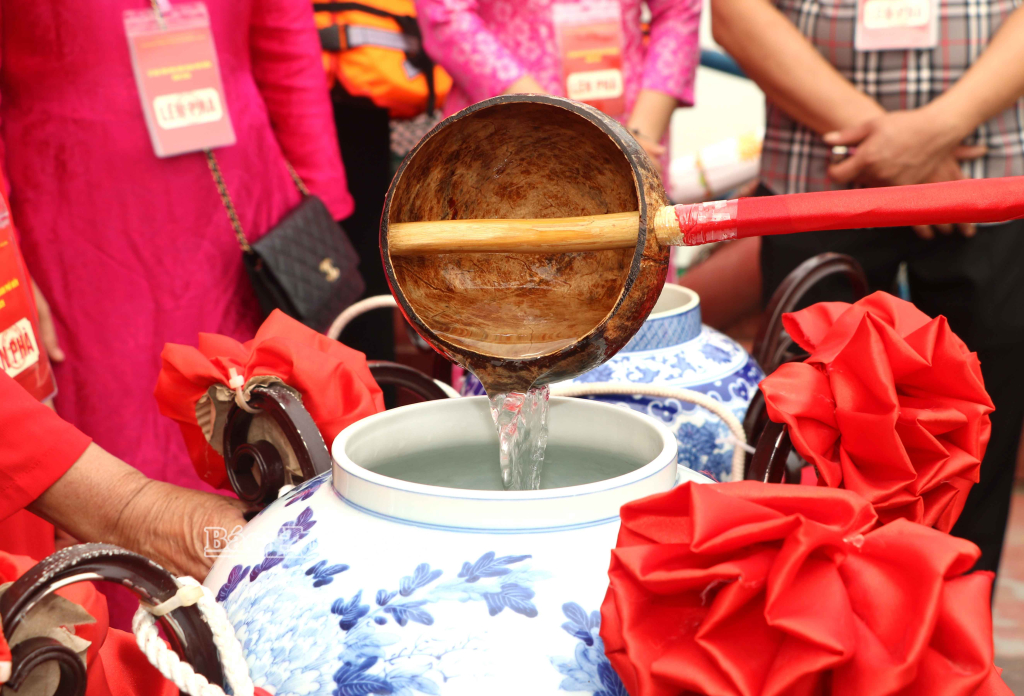 Nước thiêng từ sông Hồng được đổ vào choé. 