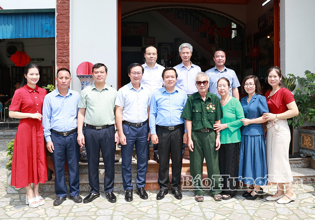 Đồng chí Phạm Quang Ngọc, Ủy viên Ban Chấp hành Trung ương Đảng, Bí thư Tỉnh ủy và các đại biểu chụp ảnh lưu niệm cùng gia đình bệnh binh Luyện Viết Chiều.