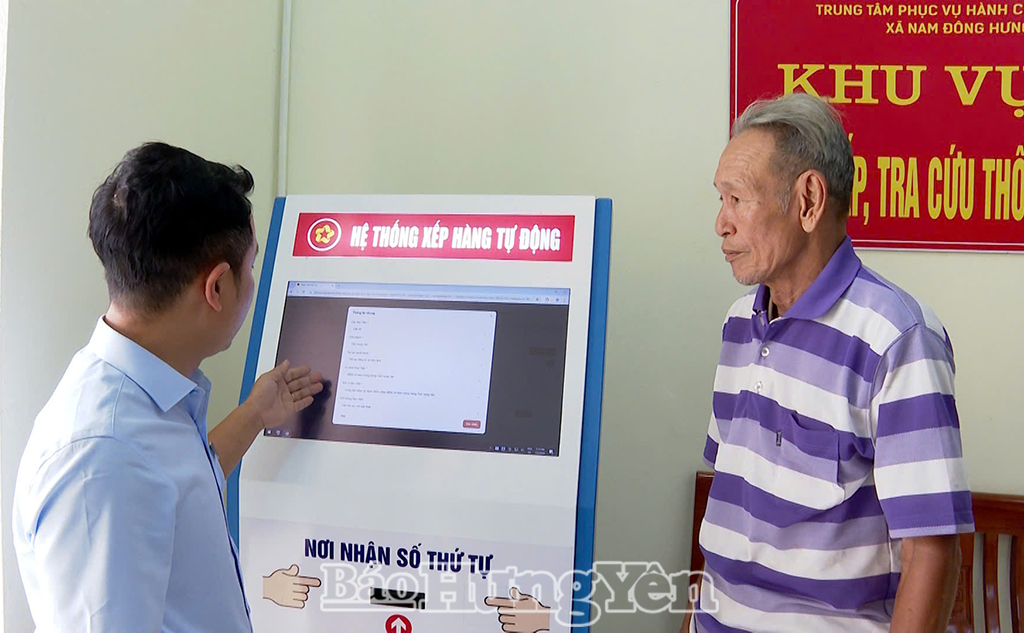 Cán bộ Trung tâm Phục vụ hành chính công xã Nam Đông Hưng hỗ trợ người dân lấy số tự động.