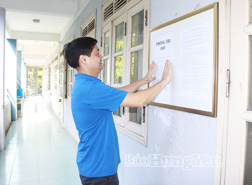 Cán bộ nhà trường dán danh sách phòng thi tại Trường THPT Chuyên Hưng Yên.