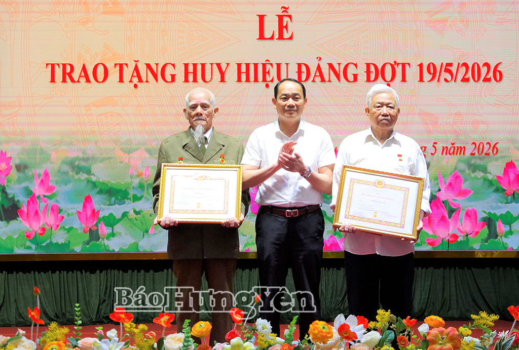 Đồng chí Bí thư Đảng ủy phường trao Huy hiệu 65 năm tuổi Đảng tặng đảng viên. Ảnh: Vân Anh 
