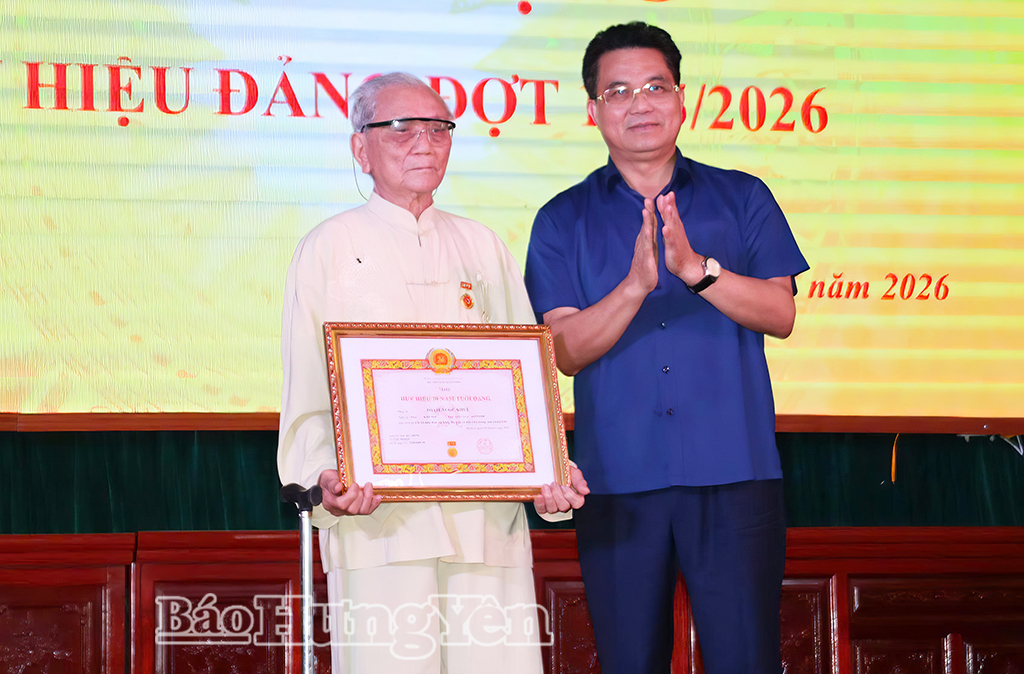 Đồng chí Lê Quang Hòa, Ủy viên Ban Thường vụ Tỉnh ủy, Phó Chủ tịch UBND tỉnh trao Huy hiệu 70 năm tuổi Đảng tặng đảng viên Phạm Ngọc Khuê.