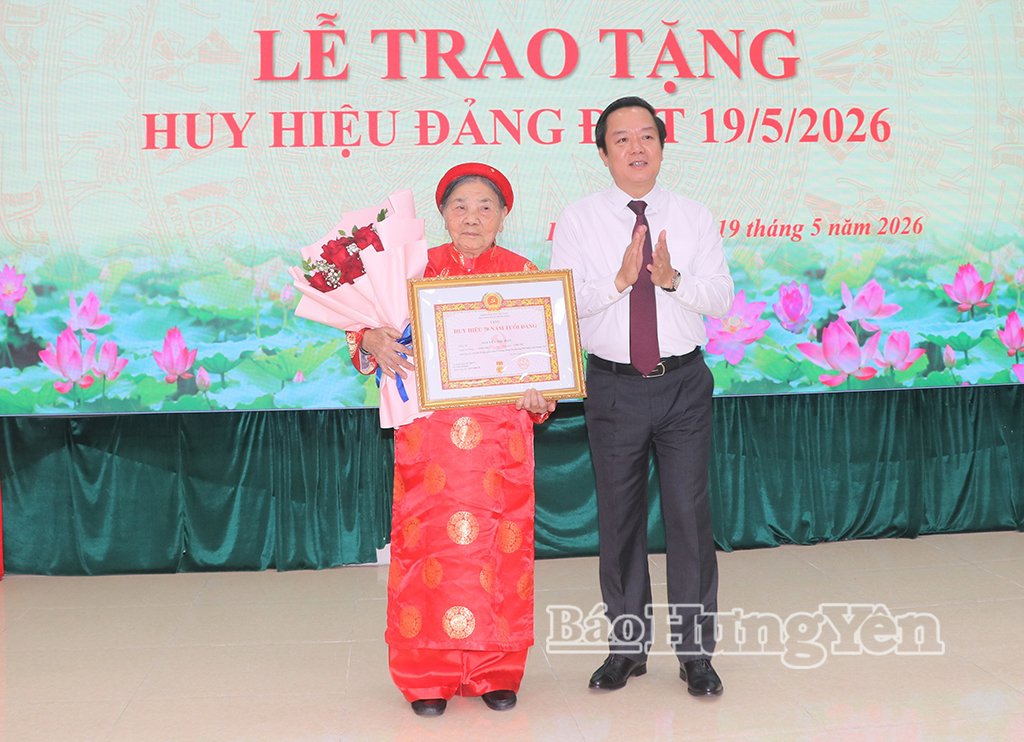 Đồng chí Phạm Quang Ngọc, Ủy viên Ban Chấp hành Trung ương Đảng, Bí thư Tỉnh ủy trao Huy hiệu 70 năm tuổi Đảng tặng đảng viên Nguyễn Thị Mận.