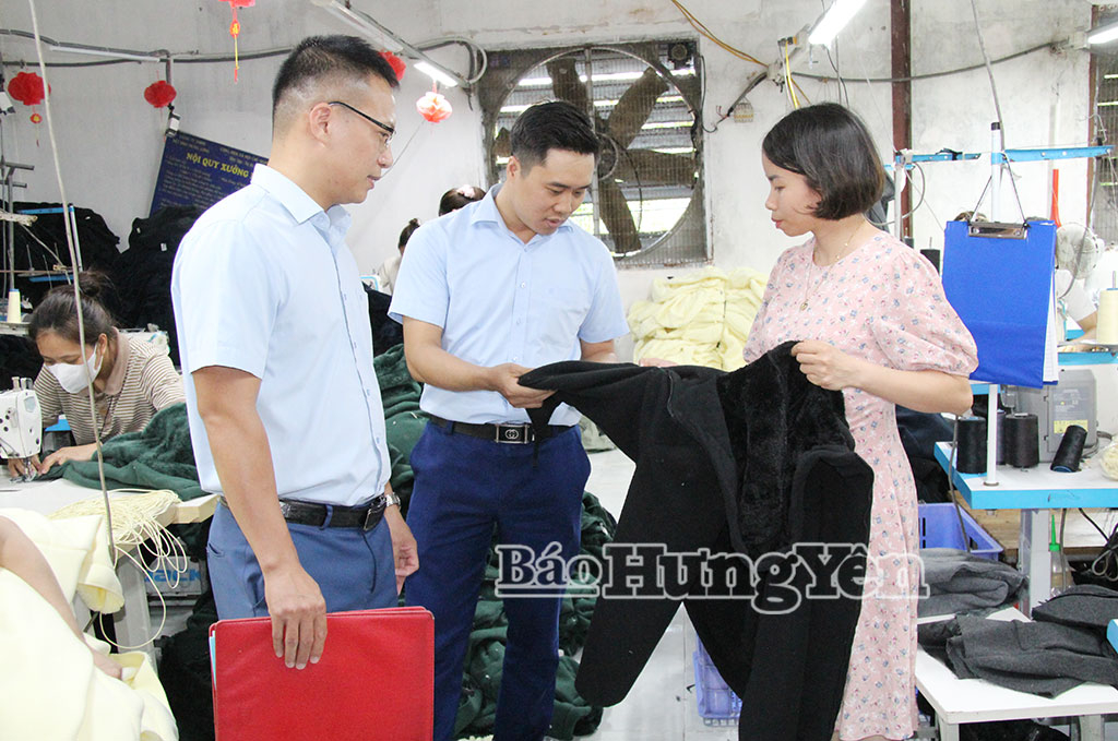 Cán bộ Quỹ tín dụng nhân dân Chí Hòa, xã Hồng Minh kiểm tra hiệu quả nguồn vốn vay tại xưởng may chị Tạ Thị Thêu, thôn Thanh Lãng.