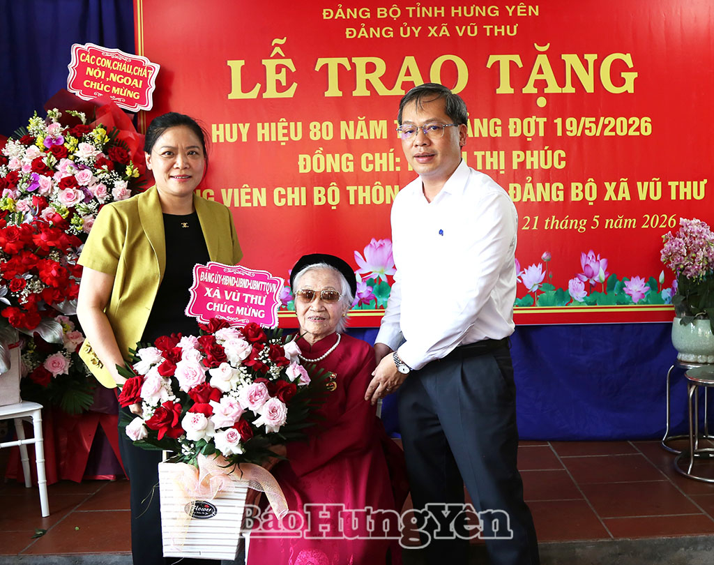 Lãnh đạo Đảng ủy xã Vũ Thư tặng hoa chúc mừng đảng viên Khiếu Thị Phúc, Chi bộ thôn Vô Ngại nhận Huy hiệu 80 năm tuổi Đảng.