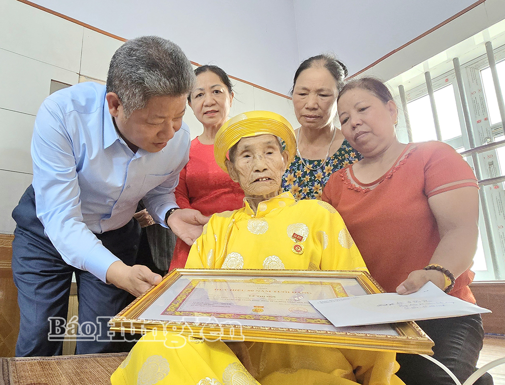 Đồng chí Nguyễn Mạnh Quyền, Phó Bí thư Tỉnh ủy, Chủ tịch UBND tỉnh trao Huy hiệu 80 năm tuổi Đảng tặng đảng viên Lê Thị Hợi, Chi bộ thôn Thanh Đông, Đảng bộ xã Đồng Châu.