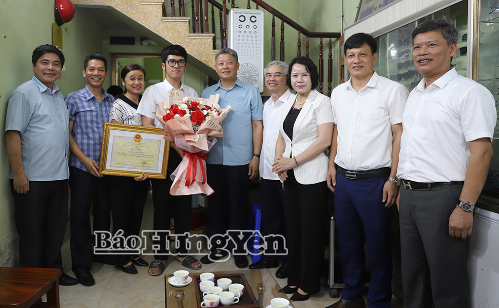 Đồng chí Nguyễn Mạnh Quyền, Phó Bí thư Tỉnh ủy, Chủ tịch UBND tỉnh và các đại biểu chụp ảnh lưu niệm với em Hoàng Quang Minh và gia đình.