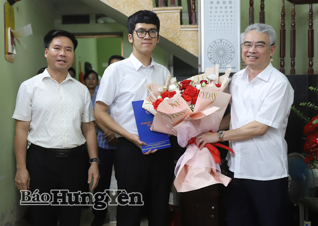 Đồng chí Phạm Đồng Thụy, Ủy viên Ban Thường vụ Tỉnh ủy, Giám đốc Sở Giáo dục và Đào tạo tặng hoa chúc mừng em Hoàng Quang Minh.