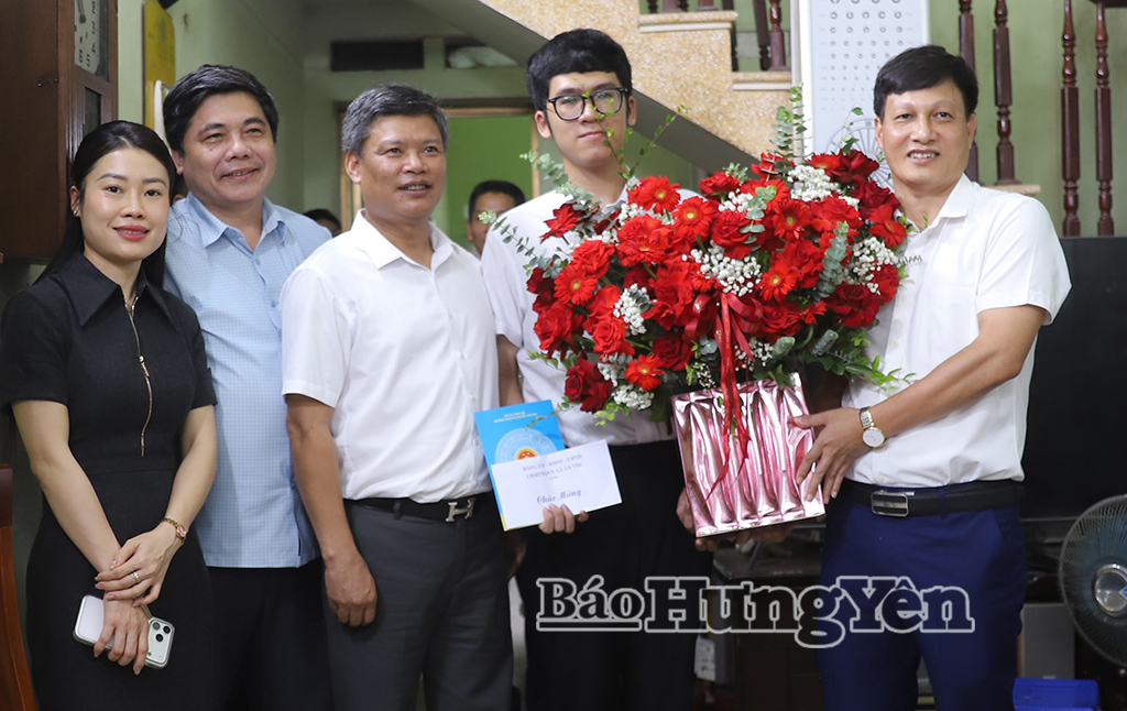 Lãnh đạo xã Ân Thi tặng hoa chúc mừng em Hoàng Quang Minh.
