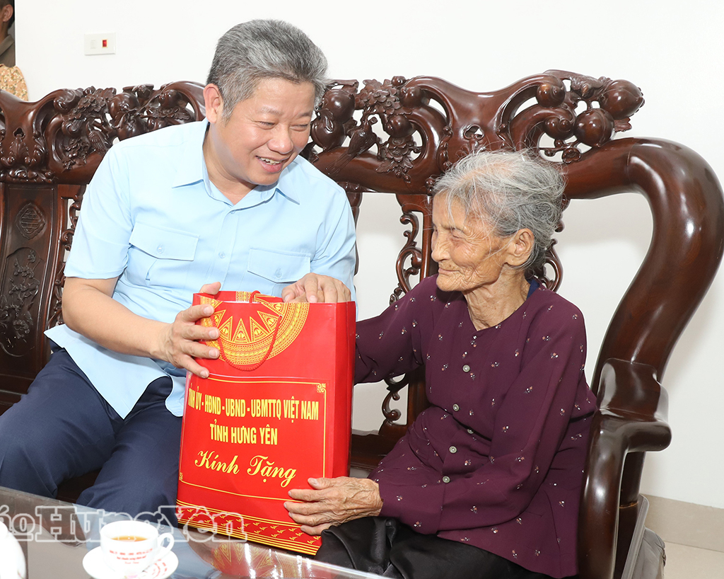 Đồng chí Nguyễn Mạnh Quyền, Phó Bí thư Tỉnh ủy, Chủ tịch UBND tỉnh ân cần hỏi thăm sức khỏe, tặng quà bà Vũ Thị Luân, vợ liệt sĩ (thôn Bình An, xã Triệu Việt Vương).