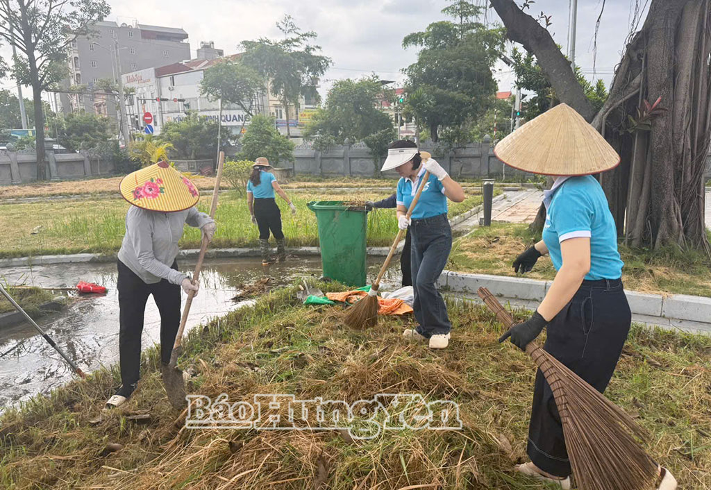 Phụ nữ xã Văn Giang vệ sinh làm sạch cảnh quan, môi trường.