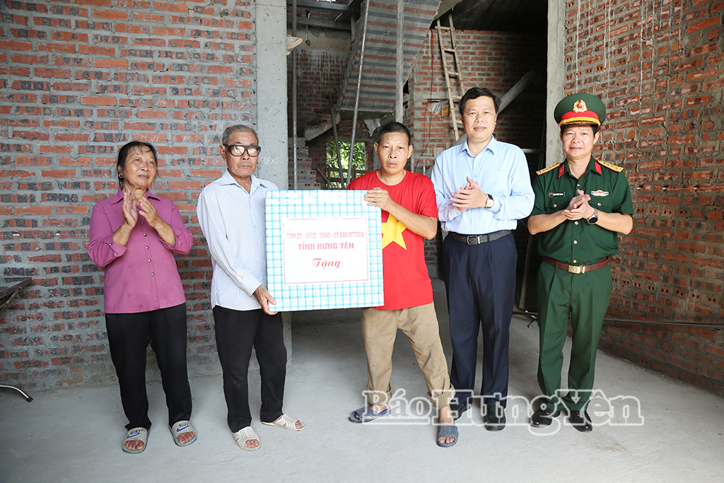 Các đồng chí: Trần Quốc Toản, Phó Bí thư Thường trực Tỉnh ủy, Chủ tịch Ủy ban MTTQ Việt Nam tỉnh; Đại tá Trịnh Hồng Phong, Ủy viên Ban Thường vụ Tỉnh ủy, Chỉ huy trưởng Bộ CHQS tỉnh tặng quà động viên gia đình hoạt động kháng chiến bị nhiễm chất độc hóa học được hỗ trợ xóa nhà tạm, nhà dột nát thôn Quỳnh Xá, xã Quỳnh An.