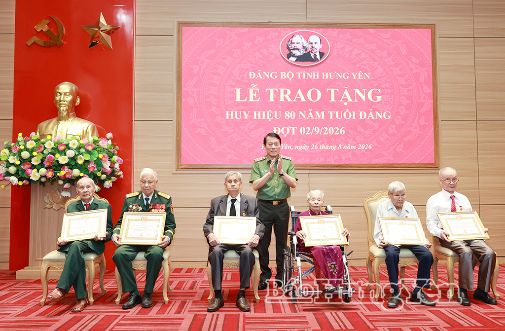  Đại tướng Lương Tam Quang, Ủy viên Bộ Chính trị, Bộ trưởng Bộ Công an trao Huy hiệu 80 năm tuổi Đảng tặng các đảng viên.