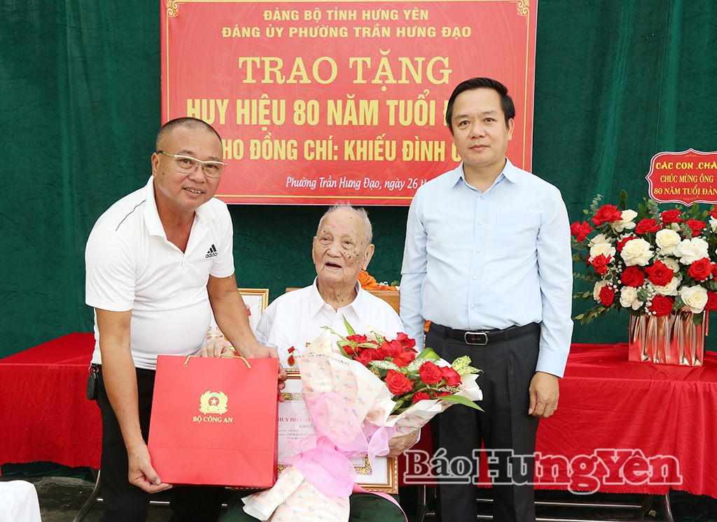 Đồng chí Phạm Quang Ngọc, Ủy viên Ban Chấp hành Trung ương Đảng, Bí thư Tỉnh ủy trao Huy hiệu 80 năm tuổi Đảng, hoa và quà tặng đảng viên Khiếu Đình Cải, sinh hoạt tại Chi bộ tổ dân phố Phú Xuân, Đảng bộ phường Trần Hưng Đạo.