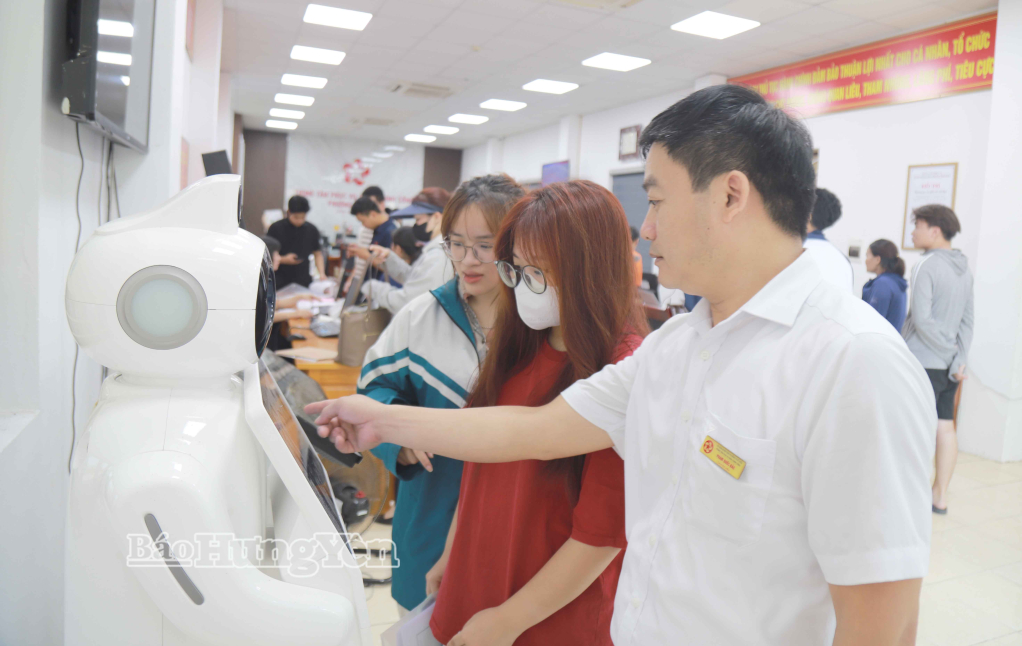 Công chức phường Phố Hiến hướng dẫn người dân sử dụng rô-bốt hướng dẫn thông tin thủ tục hành chính.