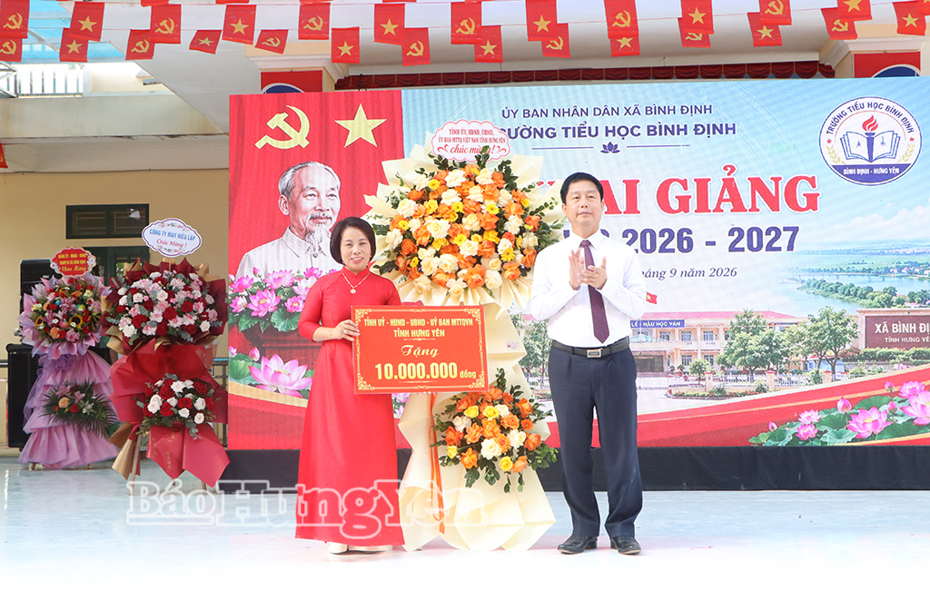 Đồng chí Vũ Thanh Vân, Ủy viên Ban Thường vụ Tỉnh ủy, Giám đốc Sở Công thương tặng hoa chúc mừng lễ khai giảng năm học mới Trường Tiểu học Bình Định (xã Bình Định).