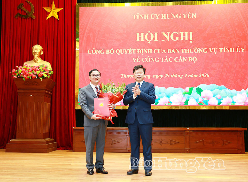 Đồng chí Trần Quốc Toản, Phó Bí thư Thường trực Tỉnh ủy, Chủ tịch Ủy ban MTTQ Việt Nam tỉnh trao quyết định và tặng hoa chúc mừng đồng chí Nguyễn Đức Cảnh.