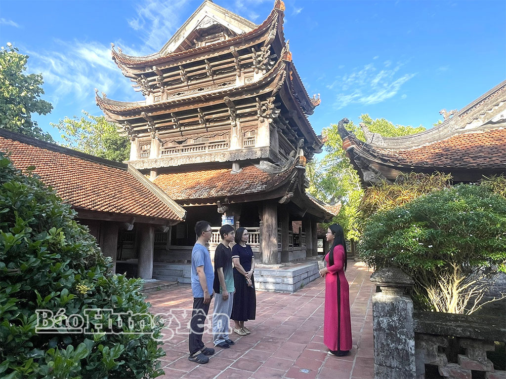 Hướng dẫn viên Ban Quản lý di tích tỉnh giới thiệu vẻ đẹp gác chuông chùa Keo tới du khách.