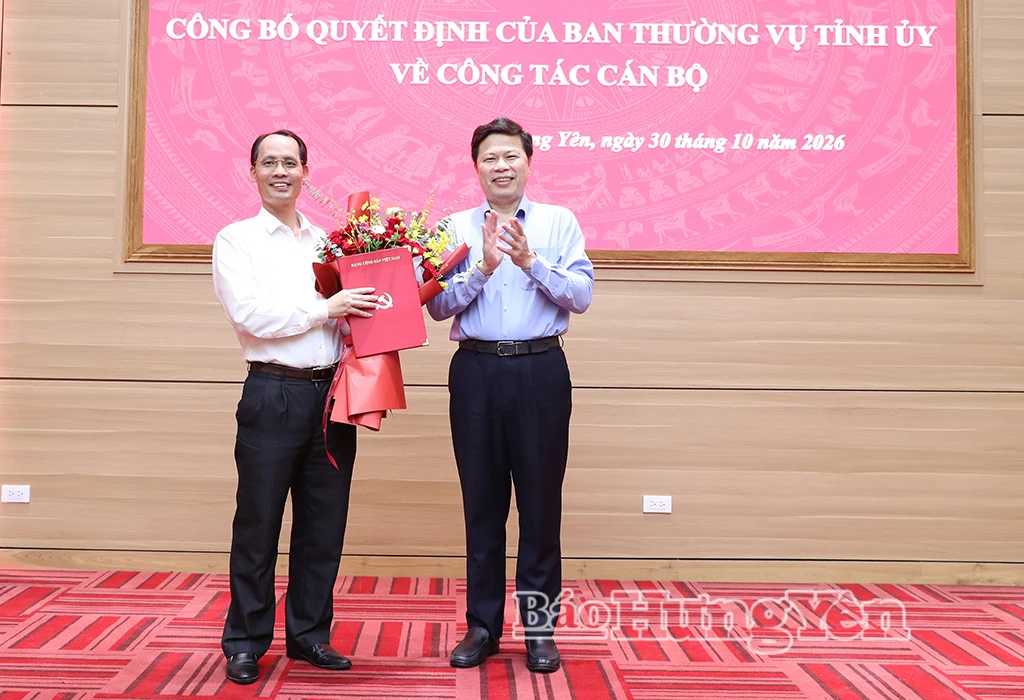 Đồng chí Trần Quốc Toản, Phó Bí thư Thường trực Tỉnh ủy, Chủ tịch Ủy ban MTTQ Việt Nam tỉnh trao quyết định và tặng hoa chúc mừng đồng chí Vương Quang Hưng.